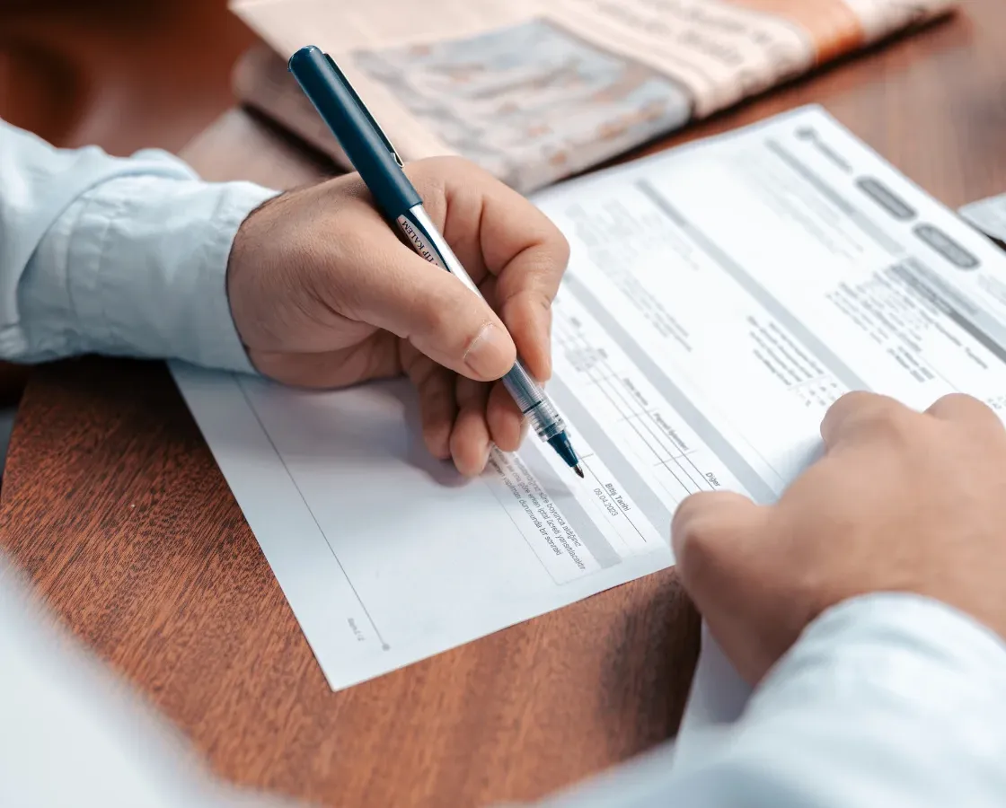 Persona firmando documento importante en asesoría de negocios